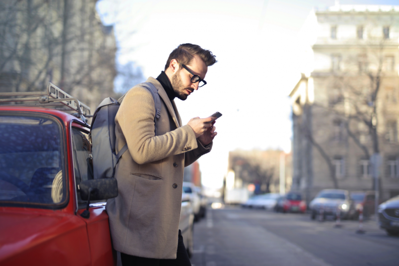 Man on the street looking at his smartphone