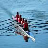 Four people on a crew team rowing together