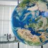 Two agile team members standing beside a large globe