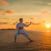 Man doing martial arts routine on the beach