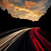 Timelapse photo of cars speeding down a road